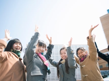 高校生が合格発表をみて喜んでいる写真