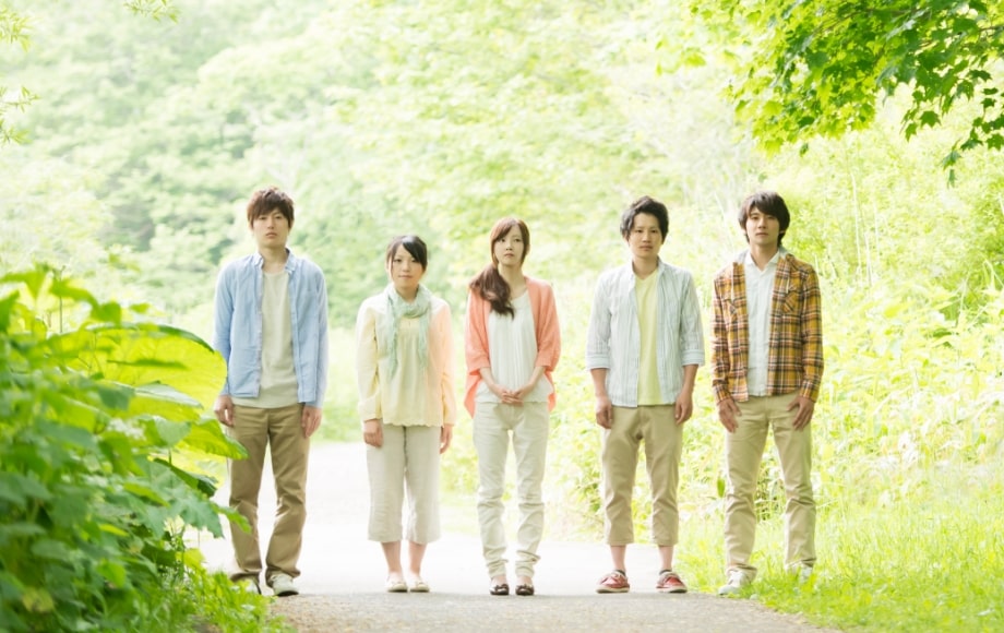 男女の学生が新緑の中で佇んでいる写真